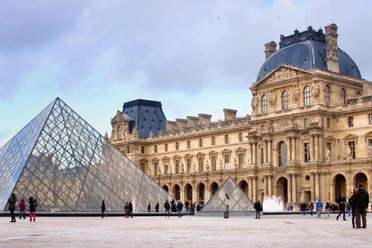 The exterior of the Louvre Museum in the fall.