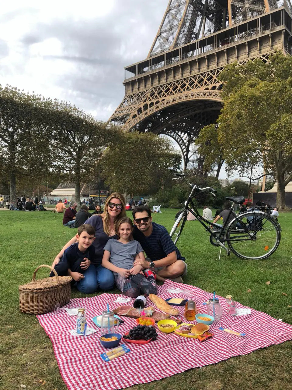 A family enjoying lunch on the lawn near the Eiffel Tower.